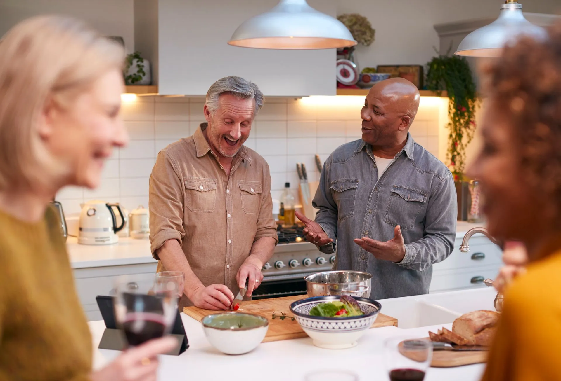 Friends laughing while making dinner together